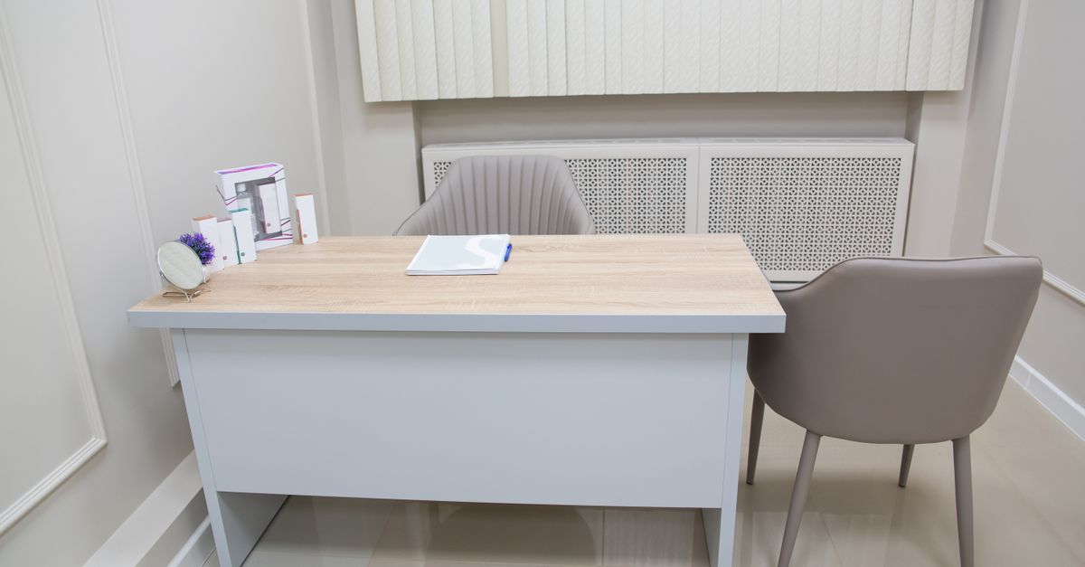 Interior de una oficina de atención con sillas, mostrador y personas esperando turno
